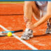 Un uomo è in ginocchio sul campo da tennis con la sua racchetta da tennis.